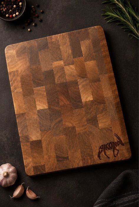 Aikona end-grain acacia cutting board on a dark kitchen counter